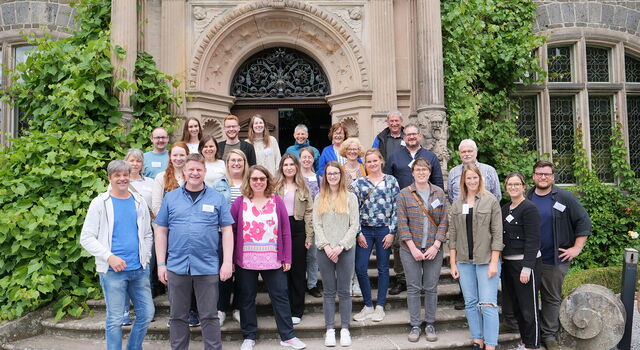 Die Teilnehmenden der Fortbildung Bauen stehen für ein Gruppenfoto auf den Treppen vor Schloss Rauischholzhausen.